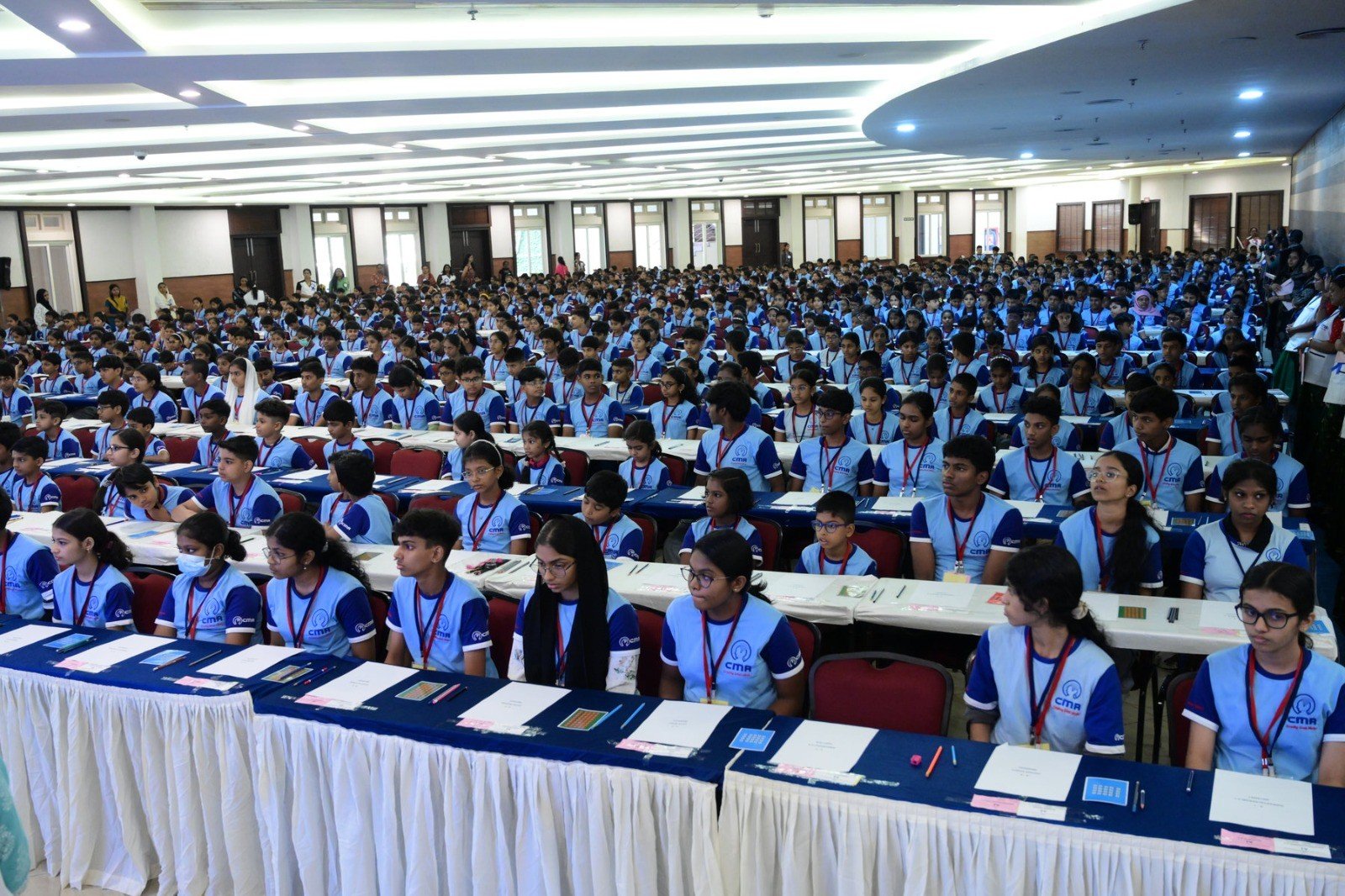 A hall full of CMA students in their CMA T-shirts, seated and ready for an assessment