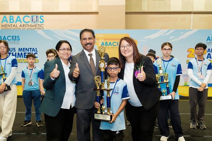 A CMA student holding a first-prize trophy