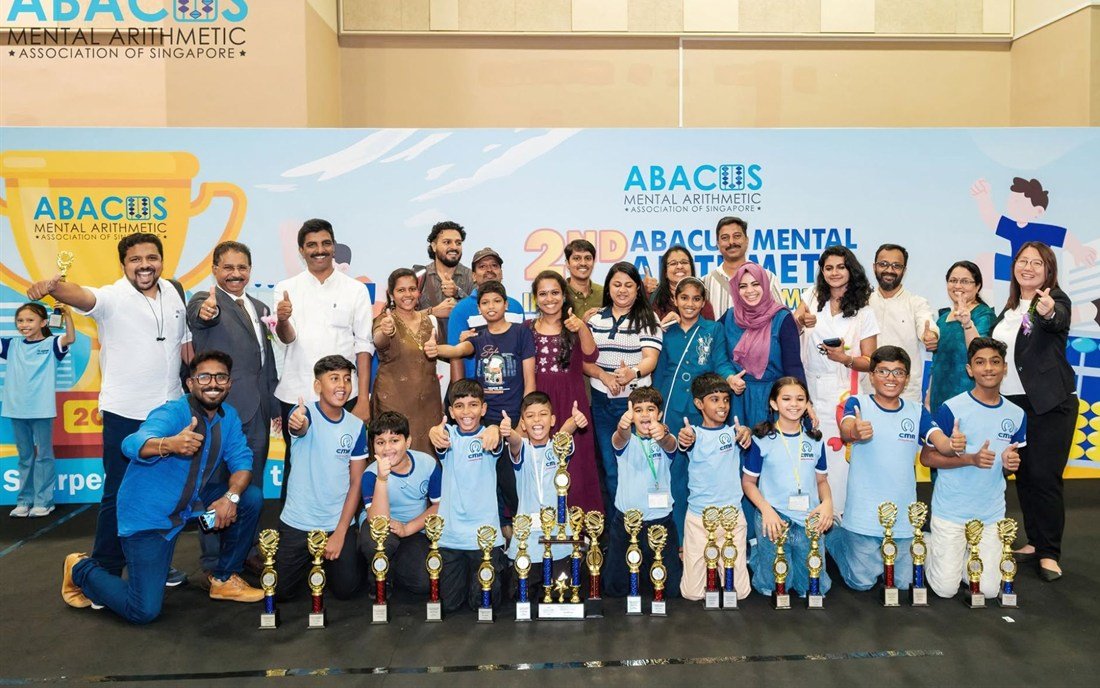 CMA India students, parents and teachers celebrating with their trophies at an international competition in Singapore